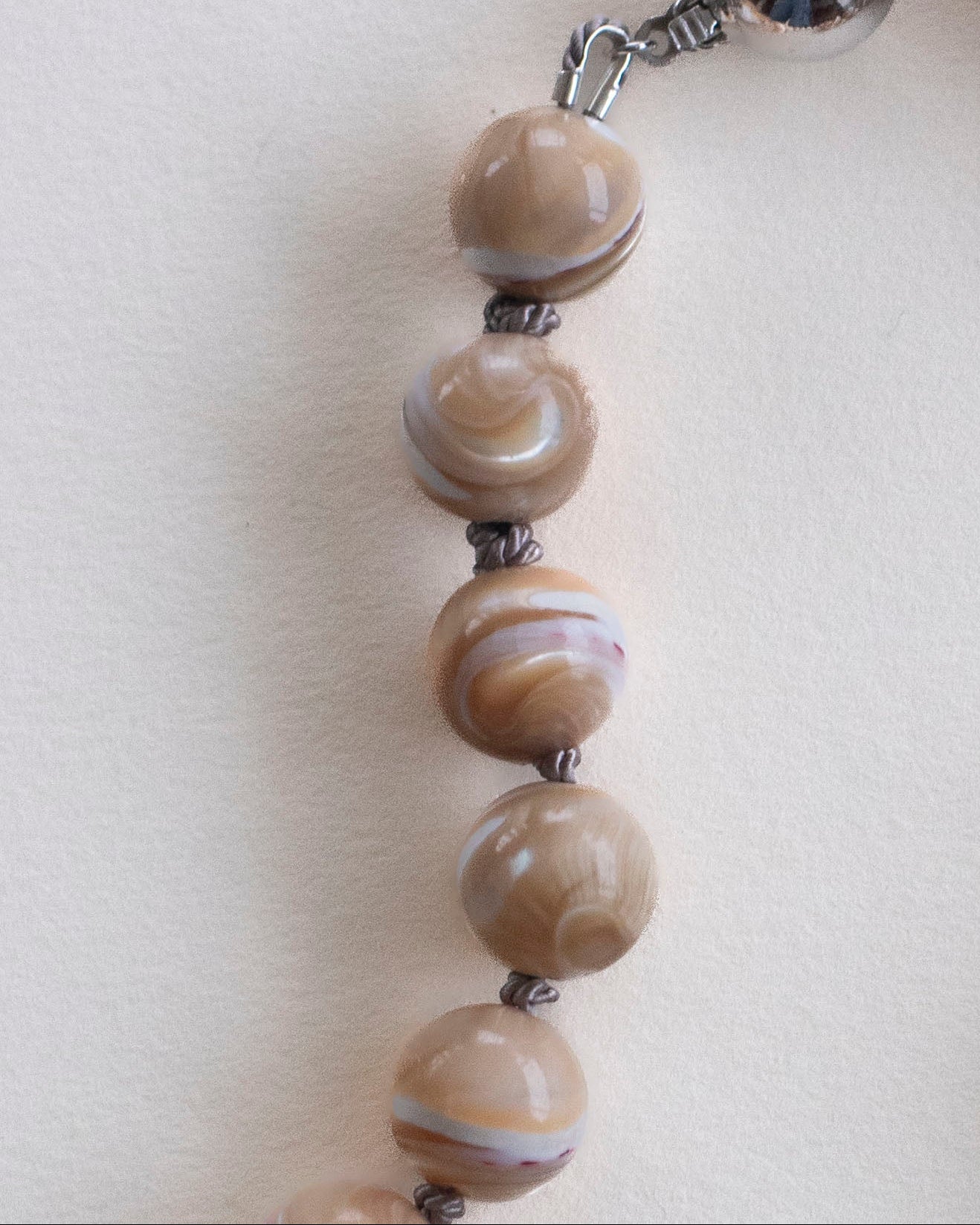 detail of mother of Pearl hand-knotted necklace on grey silk with 925 sterling silver clasp