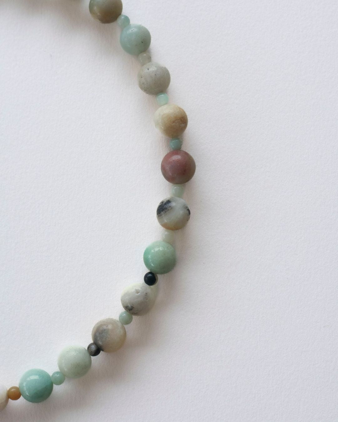 Necklace with multicolored amazonite beads on a white background