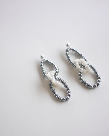 Pair of pearl and silver hematite beaded earrings on a light gray background, handmade, ethically