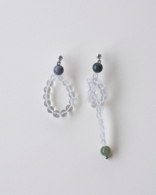 Pair of beaded earrings made in crystal quartz and indian agate on a light gray background