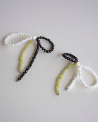 a pair of mother of pearl, garnet and lemon jasper beaded earrings, handmade in a bow form.