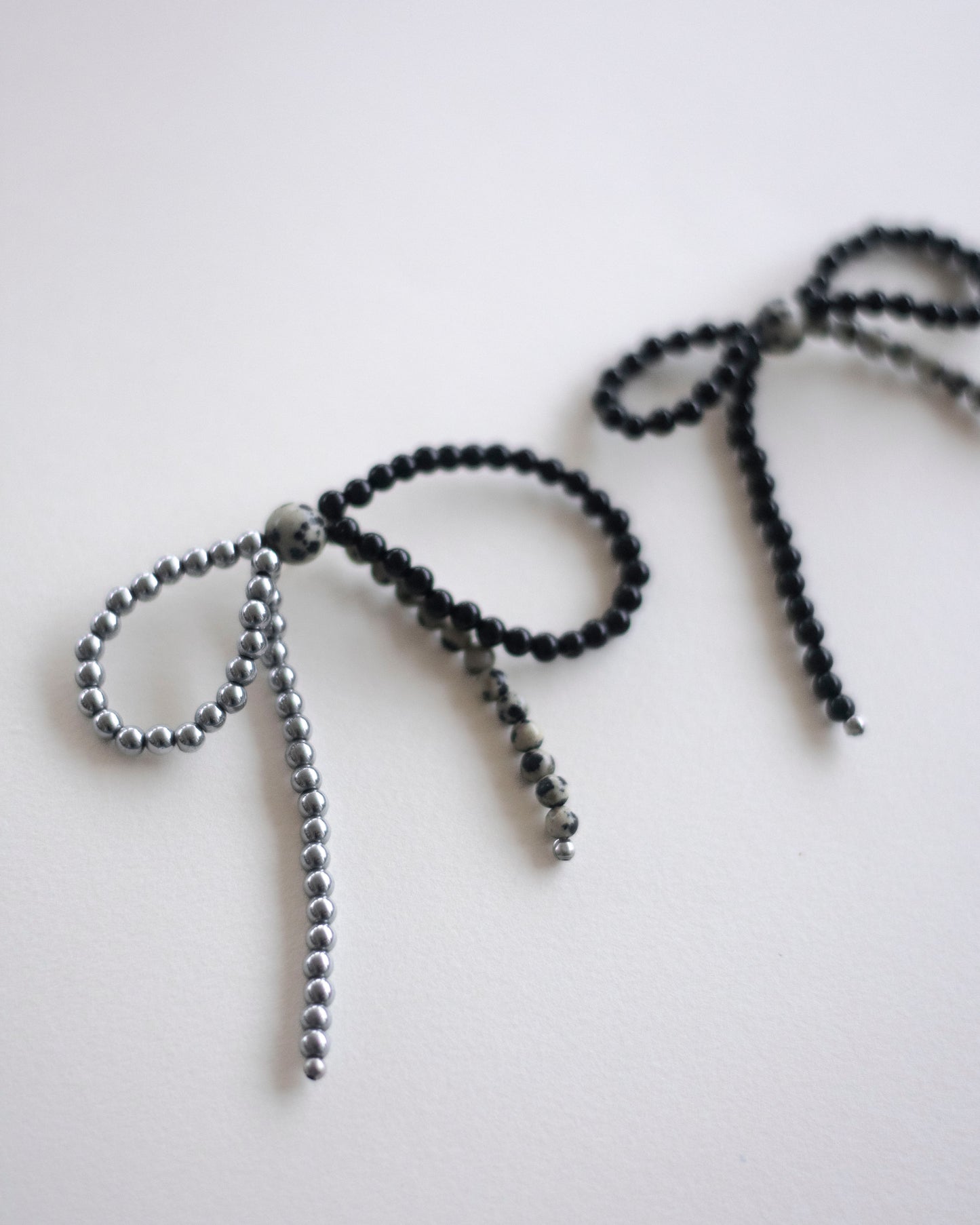 beaded bow earrings made in hematite, dalmatian jasper and onyx