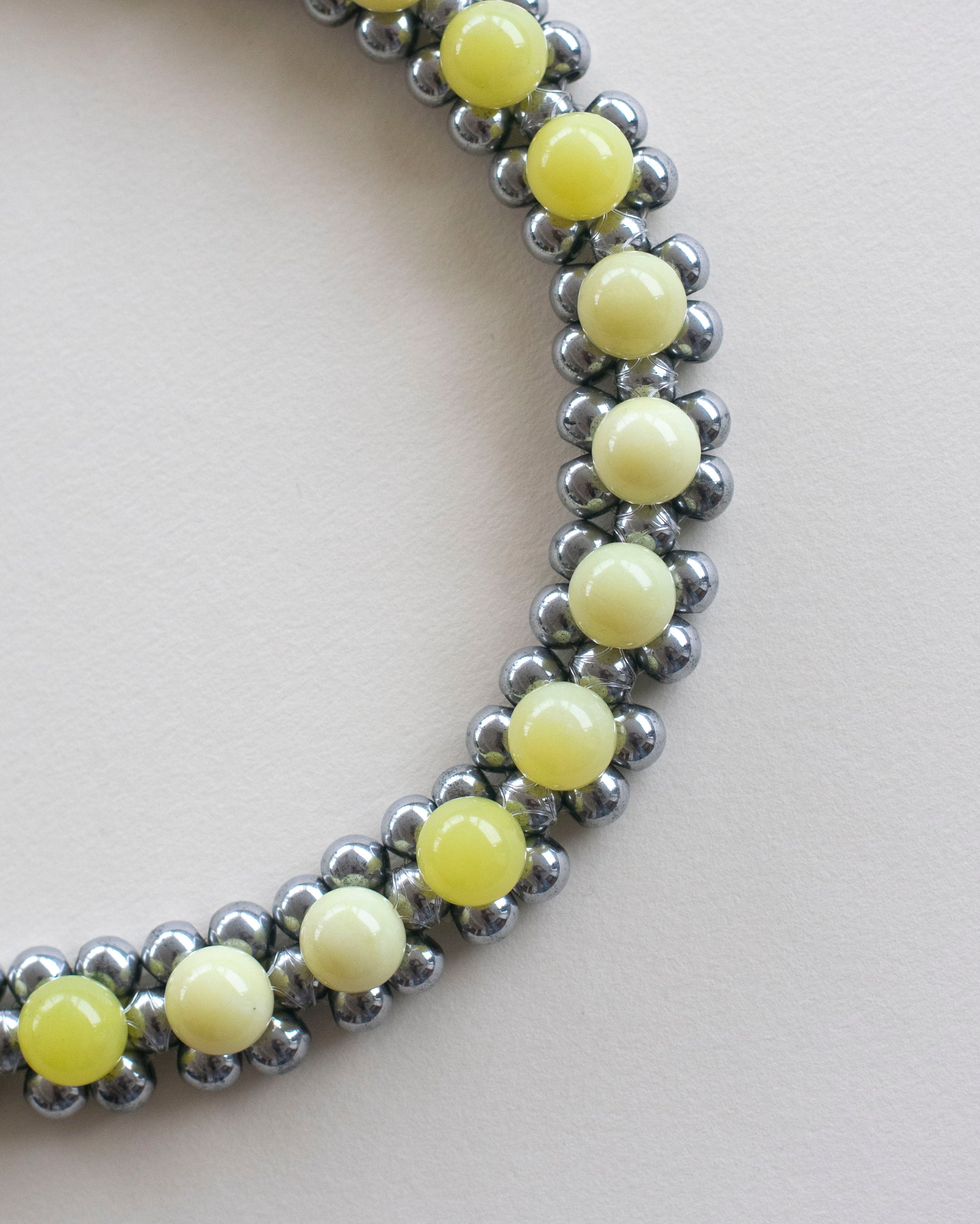close up of double layered beaded necklace, made with hematite and lemon jasper,