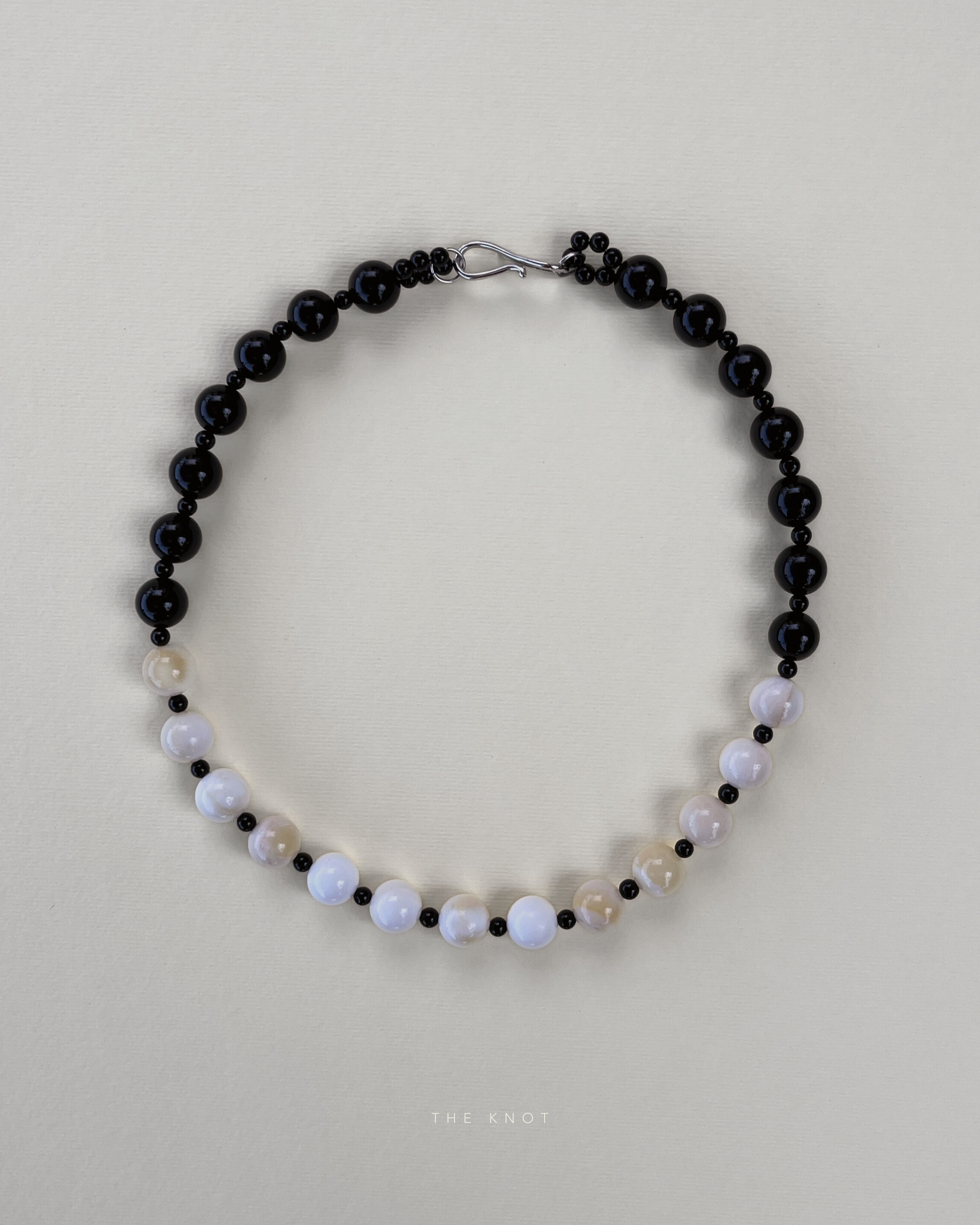 TERRA012 necklace featuring handstrung warm yellow shell beads, black obsidian, and black agate on silk thread with rhodium-plated brass clasp.