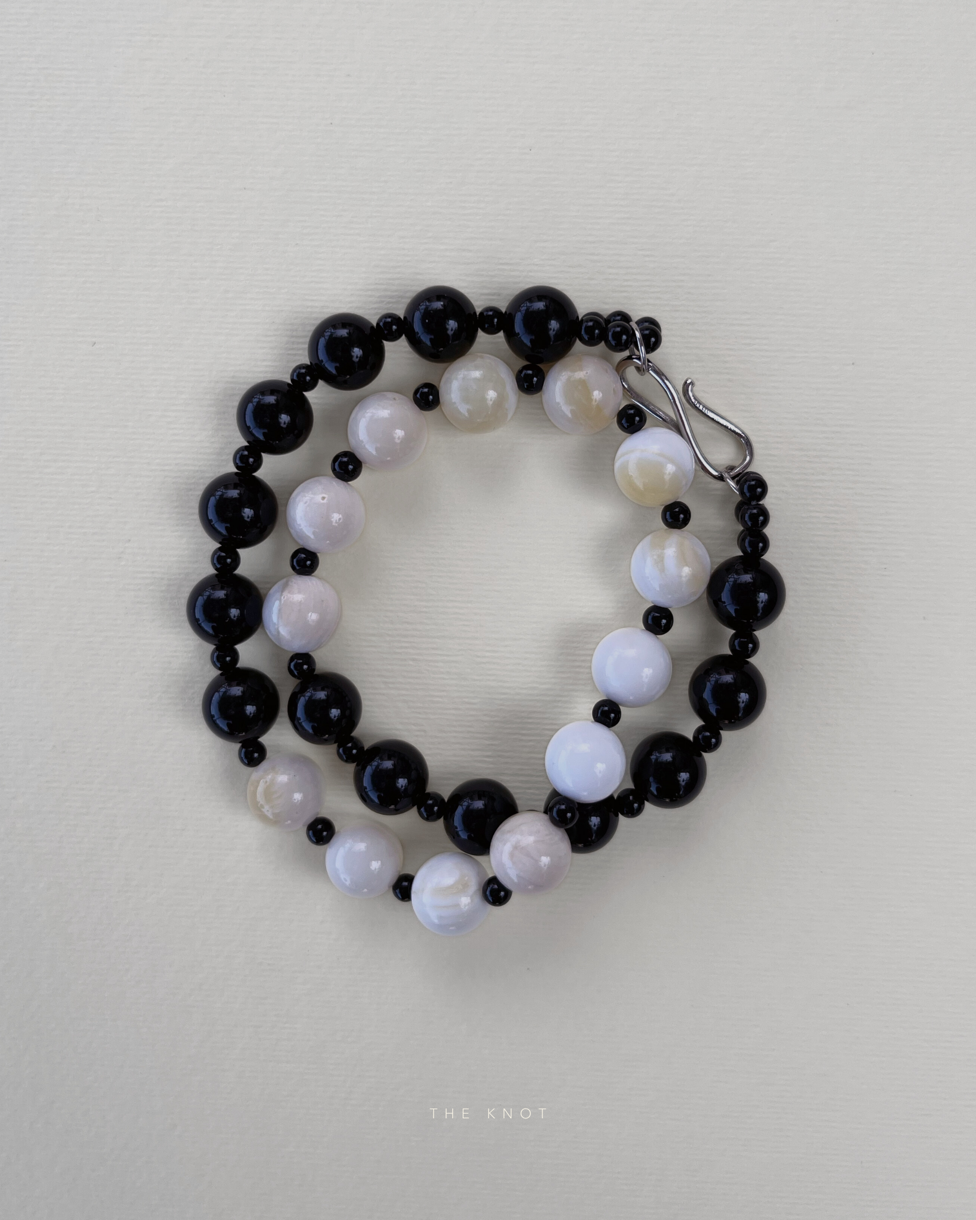 TERRA012 necklace showing yellow shell beads, black obsidian, and black agate on silk thread and brass clasp.