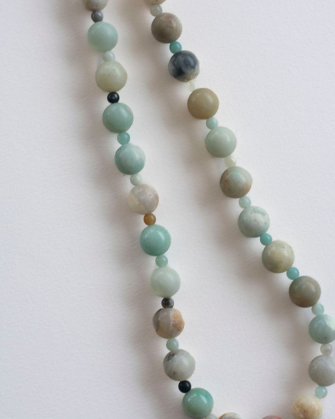 Necklace with multicolored amazonite beads on a light background