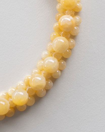 close up of honey jade beaded necklace, handmade on a light gray background