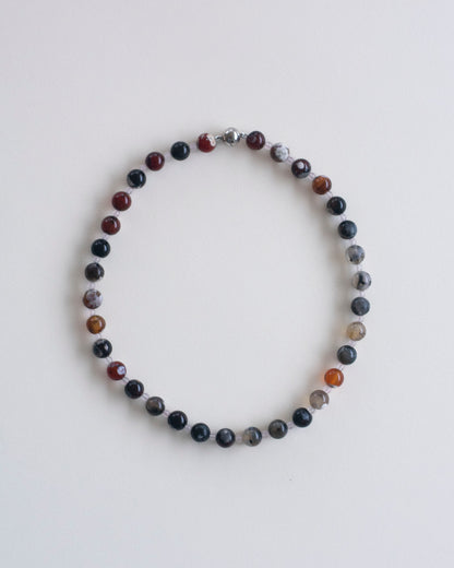 fire lace agate and rose quartz beaded necklace on a light gray background