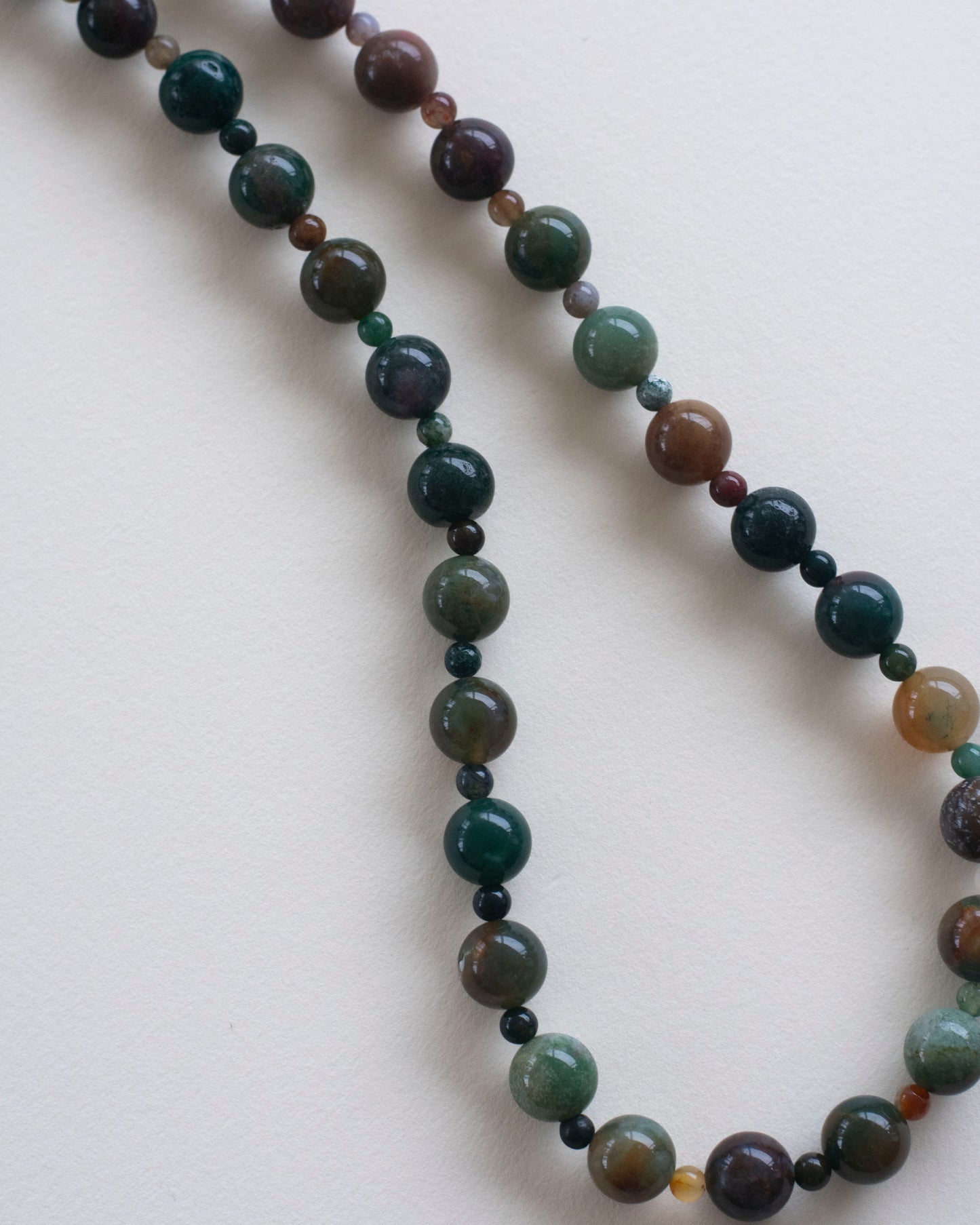 Necklace with indian agate multicolored beads on a light background