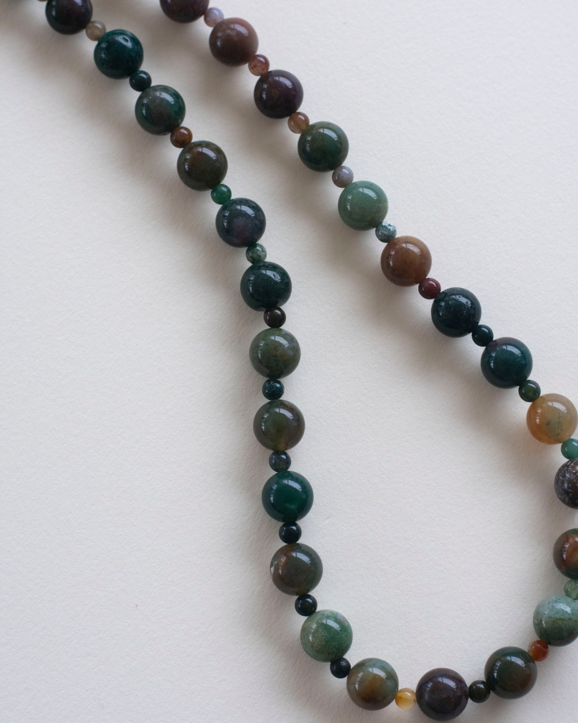 Necklace with indian agate multicolored beads on a light background