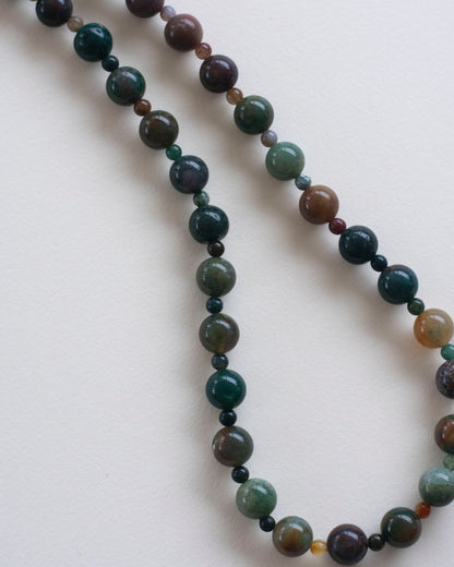Necklace with indian agate multicolored beads on a light background