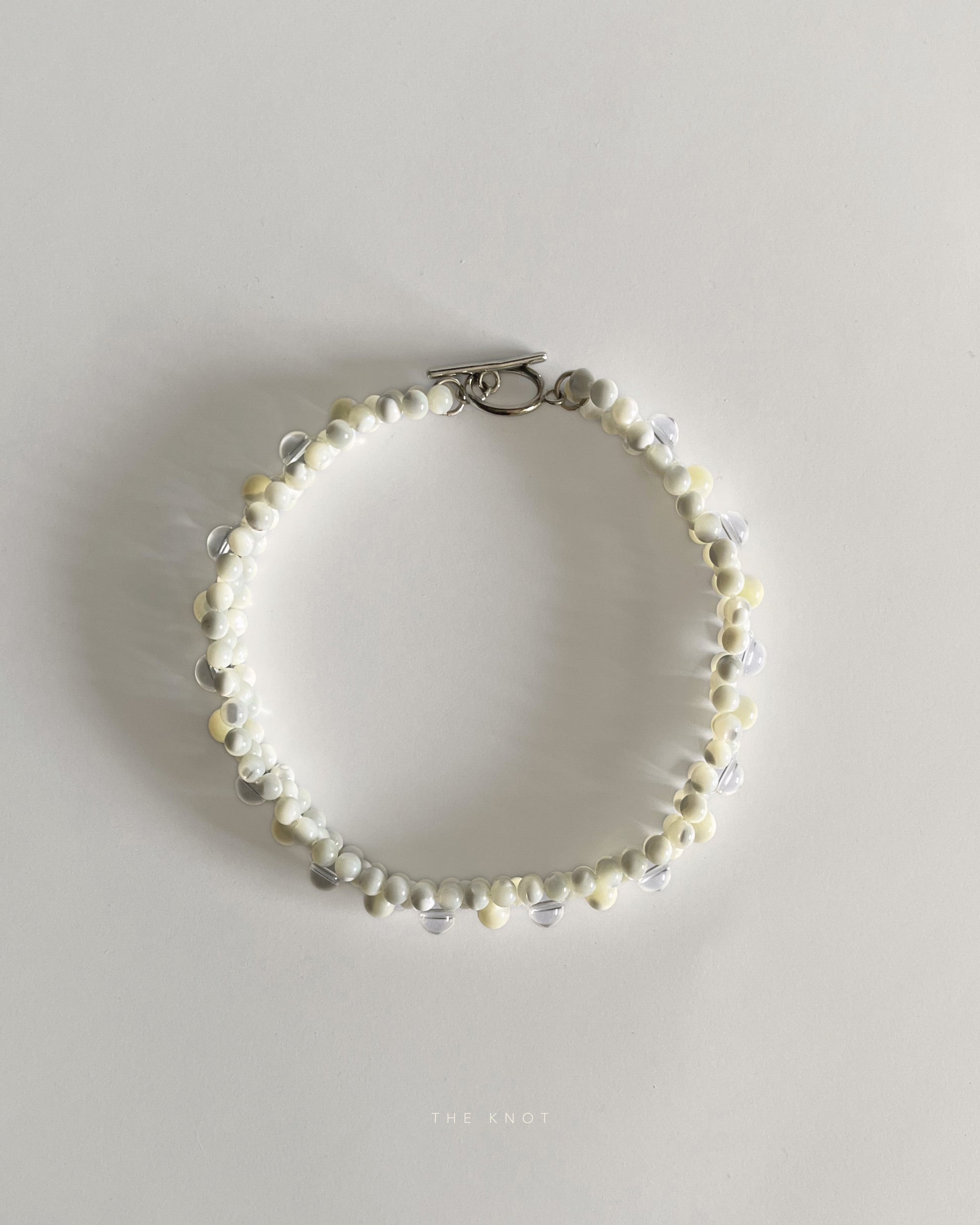 top view of hand-strung mother of pearl and crystal quartz double layered beaded necklace 